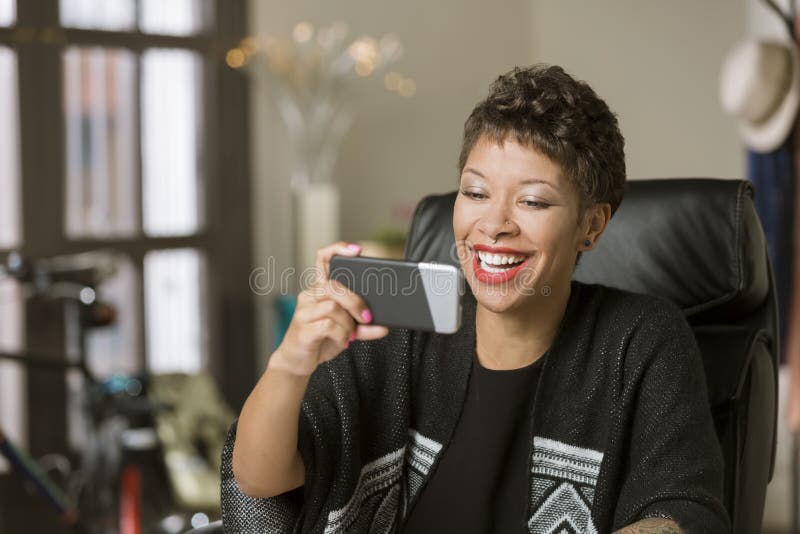 Lachende Frau mit einem Telefon in ihrem Büro lizenzfreie stockfotografie Lachende Frau mit einem Telefon in ihrem Büro lizenzfreie stockfotografie