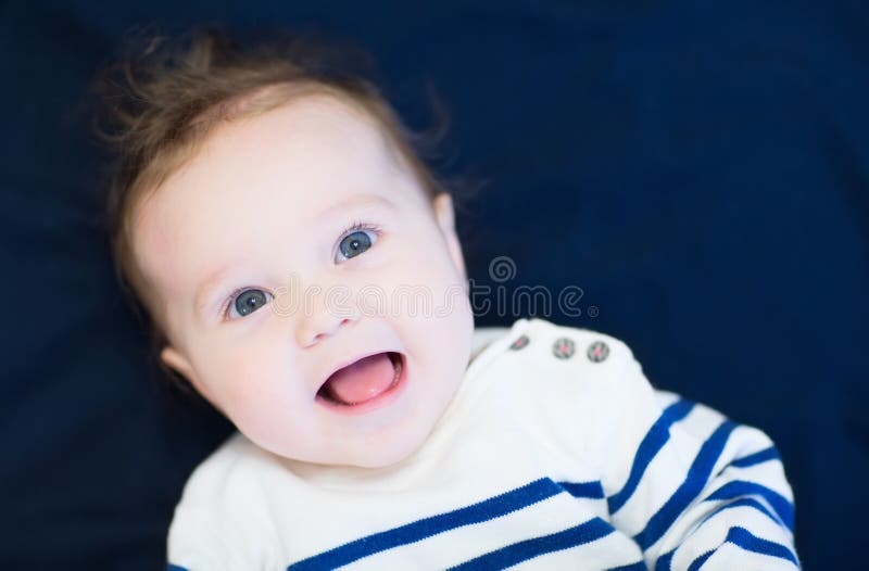 Lachende gelukkige baby in een marineoverhemd