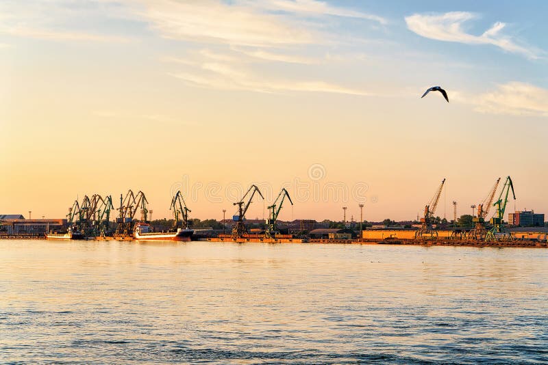 Loading cranes and oil tankers in Baltic sea in Port of Klaipeda, Lithuania. At sunset. Loading cranes and oil tankers in Baltic sea in Port of Klaipeda, Lithuania. At sunset