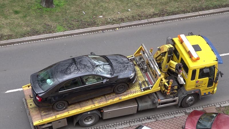 Laden des schwarzen Auto skoda schnell auf gelben europ Unterstützungs-Schleppen-LKW