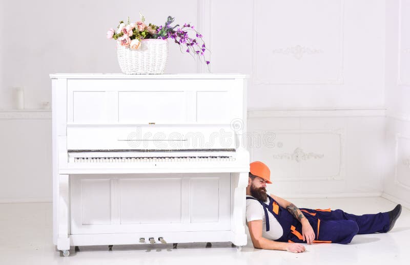 Laderhelling op pianoinstrument Lui arbeidersconcept Mens met baard, arbeider in overall en vermoeid in slaap van de helmdaling stock afbeelding Laderhelling op pianoinstrument Lui arbeidersconcept Mens met baard, arbeider in overall en vermoeid in slaap van de helmdaling stock afbeelding