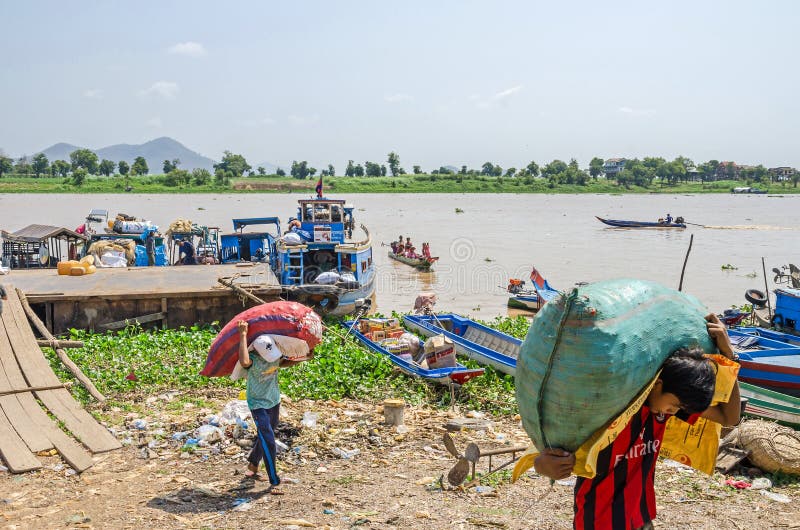 Laders die zware zakken dragen die het vrachtschip op de bank van de Mekong rivier in Kambodja leegmaken royalty-vrije stock foto's Laders die zware zakken dragen die het vrachtschip op de bank van de Mekong rivier in Kambodja leegmaken royalty-vrije stock foto's