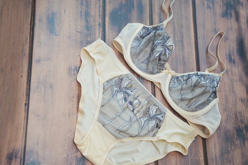 Ladies Bra and Panties on a Wooden Background. Beige Lace Lingerie