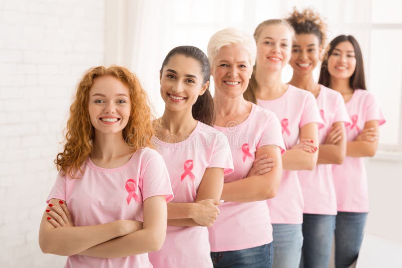 Ladies In T-Shirts With Pink Ribbons Standing Over White Wall stock images Ladies In T-Shirts With Pink Ribbons Standing Over White Wall stock images