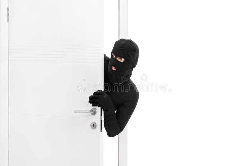 Ladrão a entrar numa divisão e a olhar à volta com cuidado imagens de stock royalty free