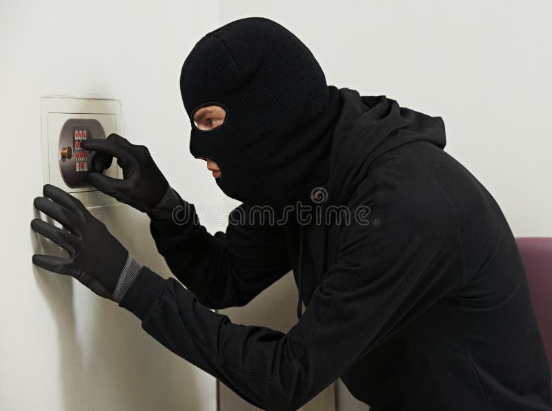 Thief burglar during home safe codebreaking. Thief burglar during home safe codebreaking