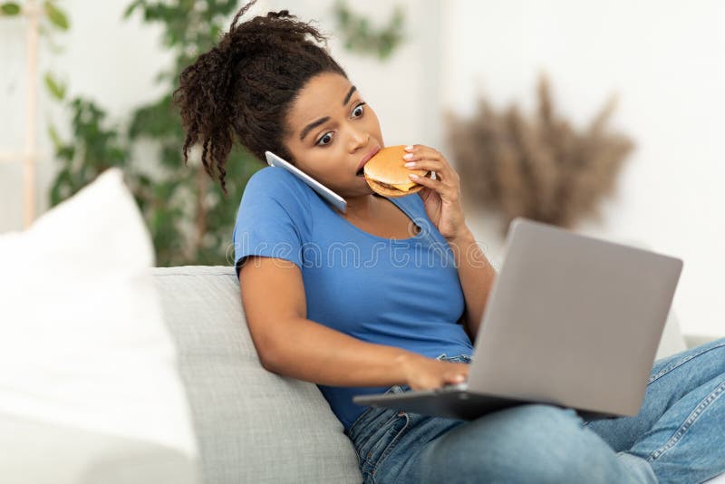Lady Eating Burger Talking On Phone, Using Laptop At Home