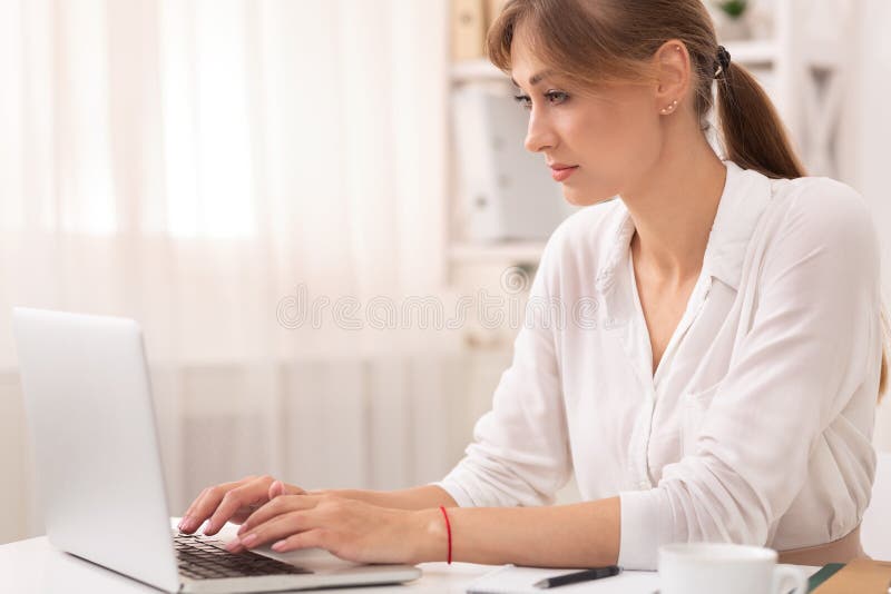 Lady Pisała Na Laptopie Artykuł Siedzący W Nowoczesnym Biurze fotografia stock Lady Pisała Na Laptopie Artykuł Siedzący W Nowoczesnym Biurze fotografia stock
