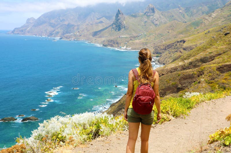 Lady tourist with a backpack standing on mountain enjoy the beautiful landscape of Tenerife Island royalty free stock photo Lady tourist with a backpack standing on mountain enjoy the beautiful landscape of Tenerife Island royalty free stock photo