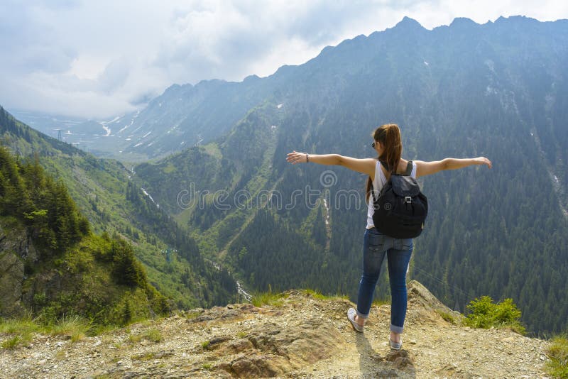 Dama turista mochila de pie sobre el la roca sobre el de montana admirar más cercano carreteras.