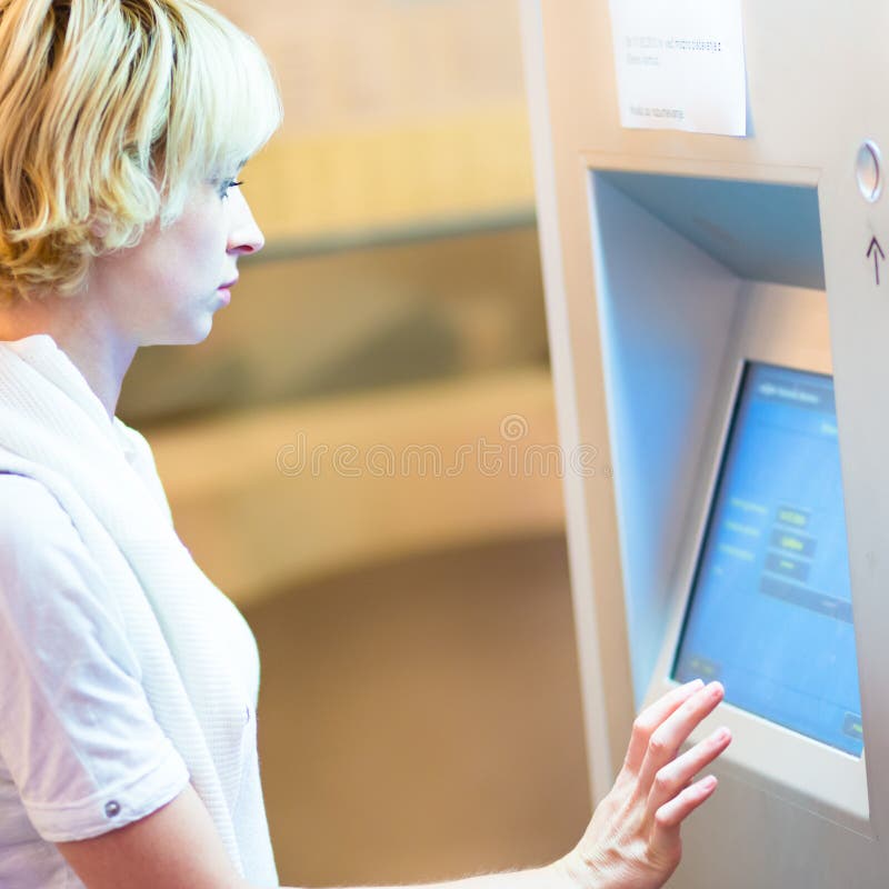 Lady using ticket vending machine. royalty free stock photography