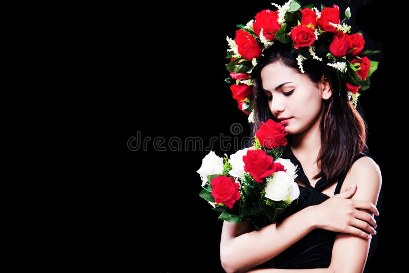 The lady is wearing black dress with rose crown on her head,holding rose bouquet in arms,posing at the right side of background royalty free stock images The lady is wearing black dress with rose crown on her head,holding rose bouquet in arms,posing at the right side of background royalty free stock images
