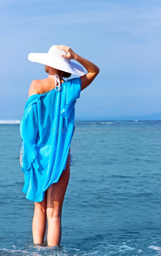 Lady in white hat on the beach