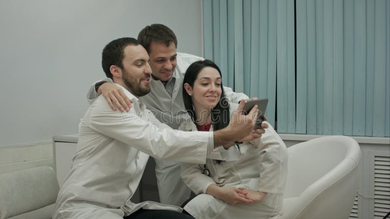 Lag av doktorer som tillsammans tar all selfie i ett medicinskt kontor arkivbild Lag av doktorer som tillsammans tar all selfie i ett medicinskt kontor arkivbild