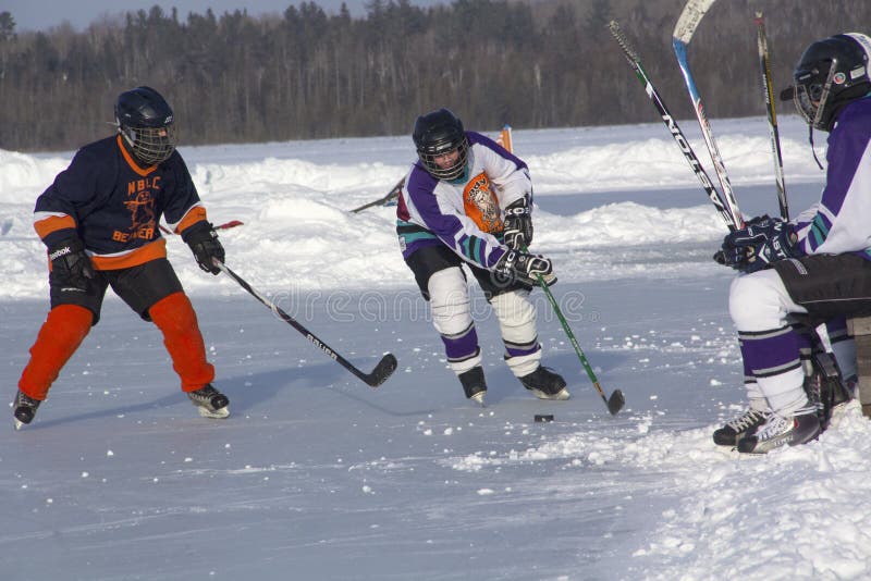 Lag för kvinna` s konkurrerar i en dammhockeyfestival i Rangeley arkivbilder Lag för kvinna` s konkurrerar i en dammhockeyfestival i Rangeley arkivbilder