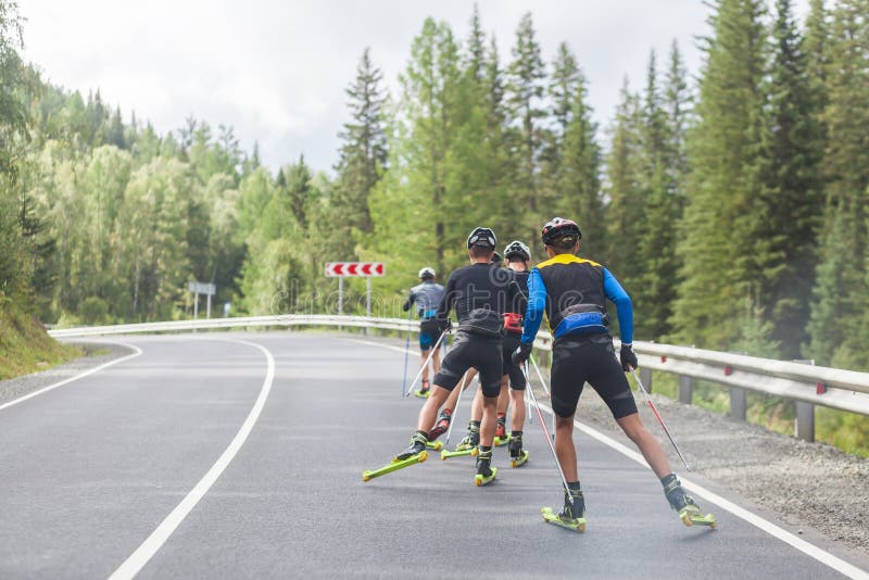 Lagbiotlonists går på rullskidor royaltyfri bild Lagbiotlonists går på rullskidor royaltyfri bild