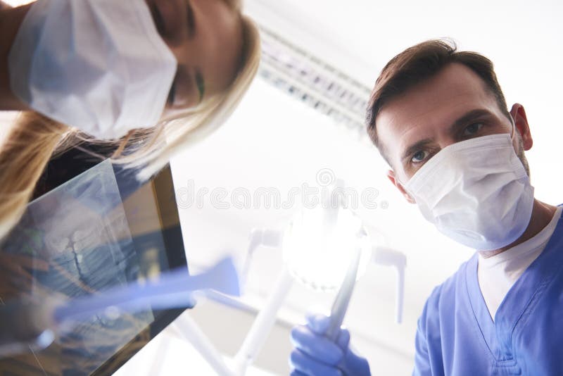 Lage hoekmening van mannelijke tandarts in de kliniek van de tandarts stock foto's Lage hoekmening van mannelijke tandarts in de kliniek van de tandarts stock foto's