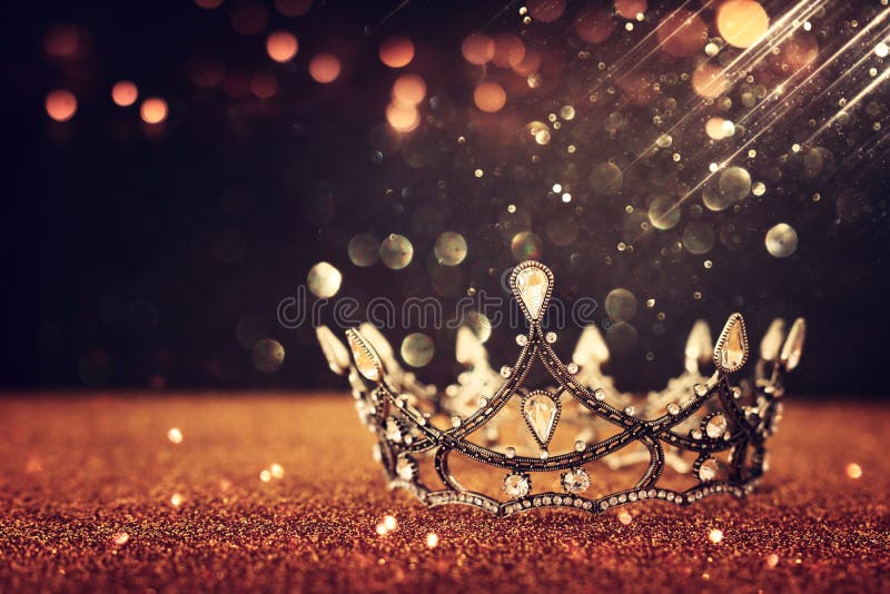 lage-sleutelafbeelding van mooie koningin/koning kroon boven gouden glittertafel oldtimers gefilterd hersenvlies middeleeuwse per
