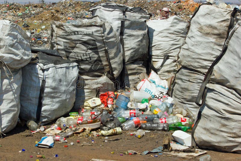Lagerfoto von Müllabfuhrtaschen und leeren Plastikflaschen auf Mülldeponie