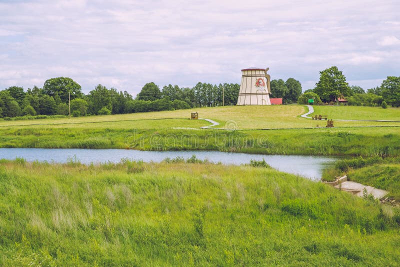 Lago con i vecchi mulini in Dunte, Lettonia Museo di Baron Munchausen immagine stock libera da diritti Lago con i vecchi mulini in Dunte, Lettonia Museo di Baron Munchausen immagine stock libera da diritti