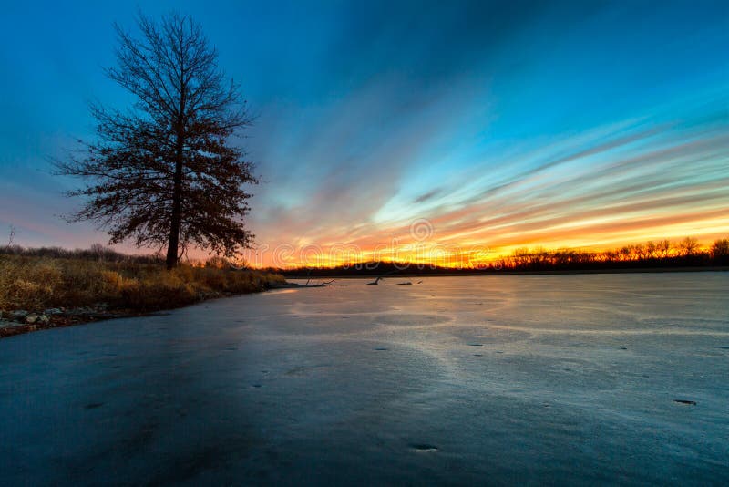 A frozen lake in Missouri during the winter at sunrise. A frozen lake in Missouri during the winter at sunrise