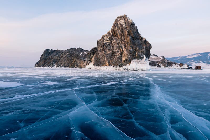 Lago congelato fendentesi dell'acqua con la montagna della roccia