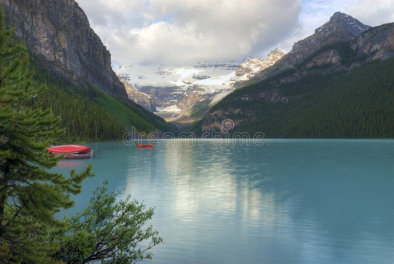 The incredible turquoise blue water of Moraine Lake in Banff National Park in Alberta Canada. The amazing color is natural and is caused by light reflecting on the rock flower which is suspended in the water. The glaciers grind up the rock as they move and then the melt water carries the rock flower into the lake. The incredible turquoise blue water of Moraine Lake in Banff National Park in Alberta Canada. The amazing color is natural and is caused by light reflecting on the rock flower which is suspended in the water. The glaciers grind up the rock as they move and then the melt water carries the rock flower into the lake.