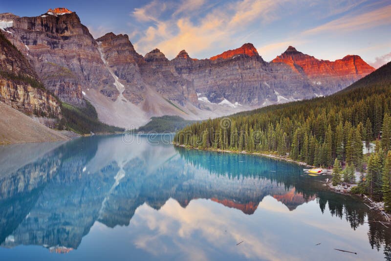 Lago no nascer do sol, parque nacional moraine de Banff, Canadá