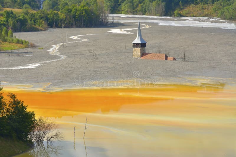 Lago rojo contaminado con árboles muertos y una iglesia inundada imagen de archivo Lago rojo contaminado con árboles muertos y una iglesia inundada imagen de archivo