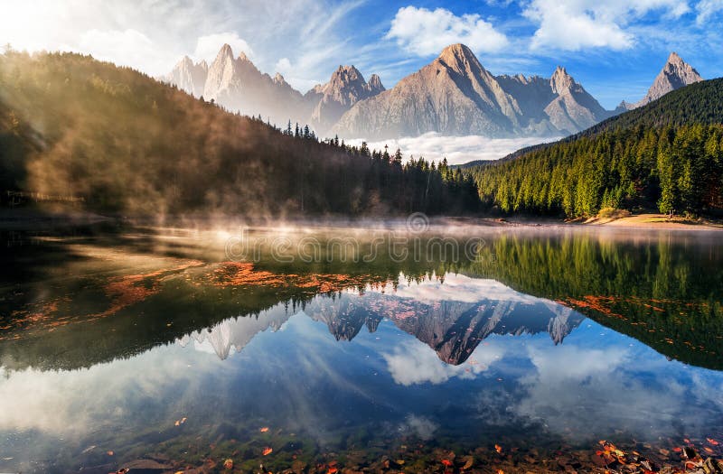 Lago splendido della montagna in nebbia di autunno