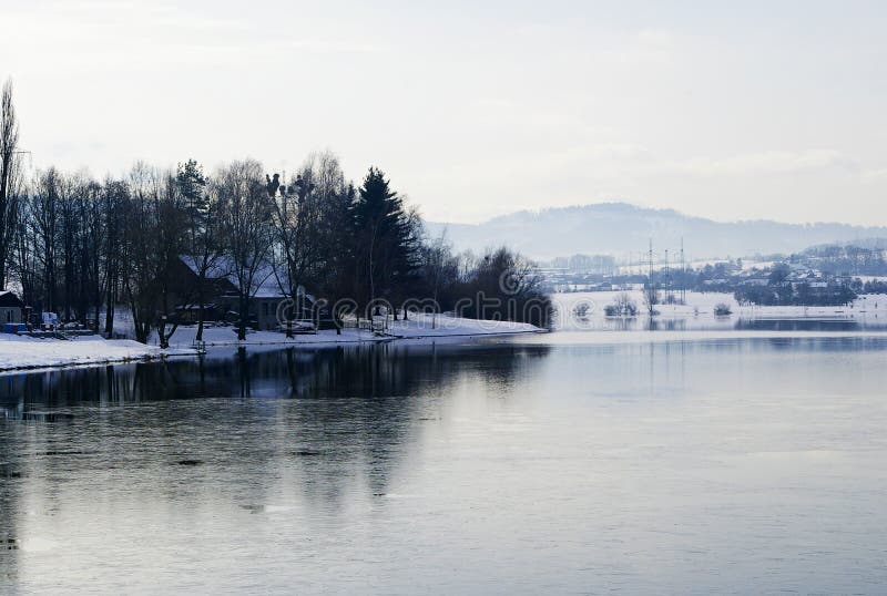 Winter landscape with frozen lake and hills in mirror reflection, located in Moravian Beskydy mountains, part of Czech Republic. Winter landscape with frozen lake and hills in mirror reflection, located in Moravian Beskydy mountains, part of Czech Republic