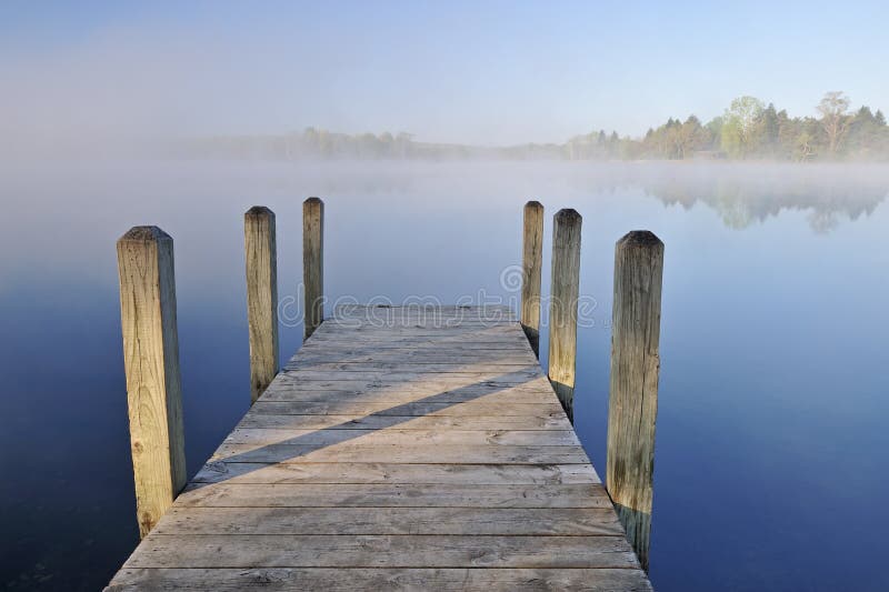 Landscape of dock and foggy, spring shoreline Whitford Lake, Fort Custer State Park, Michigan, USA. Landscape of dock and foggy, spring shoreline Whitford Lake, Fort Custer State Park, Michigan, USA