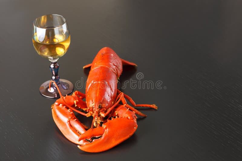 Boiled Atlantic Lobster with glass of white wine on dark wooden table. Boiled Atlantic Lobster with glass of white wine on dark wooden table.