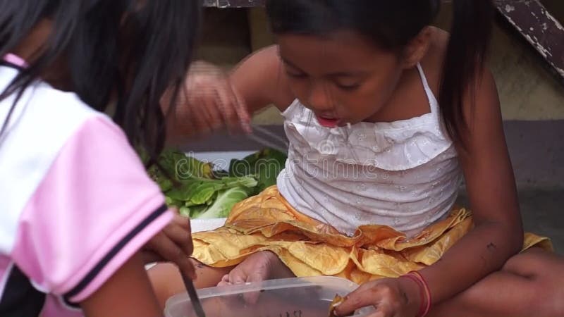 Poor girls eat with bare hands of more rice and small viands or pauper`s meal