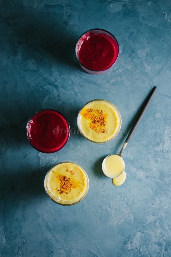 Lait d'or de yaourt avec le safran des indes et le smoothie rouge photographie stock libre de droits Lait d'or de yaourt avec le safran des indes et le smoothie rouge photographie stock libre de droits