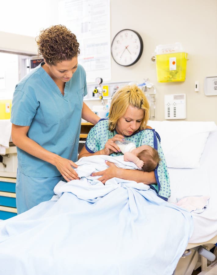 Lait de alimentation de Looking At Patient d'infirmière au bébé à images libres de droits Lait de alimentation de Looking At Patient d'infirmière au bébé à images libres de droits