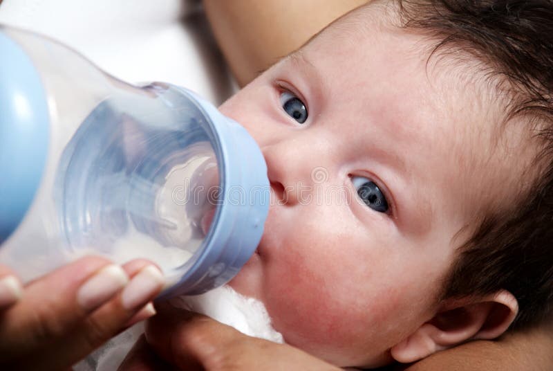 Bébé buvant du lait dans son biberon photographie stock libre de droits