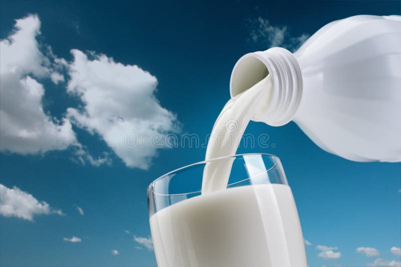 Lait frais se renversant dans une glace photographie stock Lait frais se renversant dans une glace photographie stock