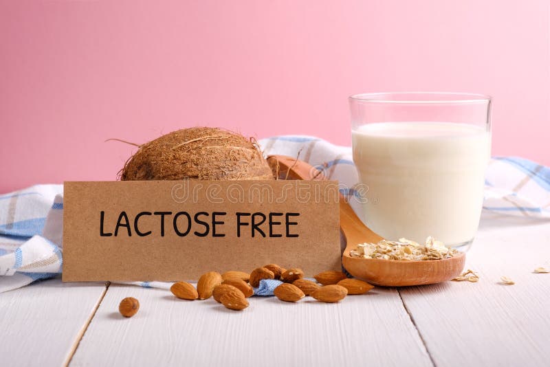Lait sans lactose Verre de lait, des écrous d'amande, des flocons d'avoine, de noix de coco et de morceau de papier avec le texte image libre de droits Lait sans lactose Verre de lait, des écrous d'amande, des flocons d'avoine, de noix de coco et de morceau de papier avec le texte image libre de droits