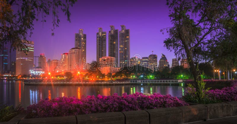 Lake in City Park under Skyscrapers at Night. Benjakiti Park in Bangkok, Thailand