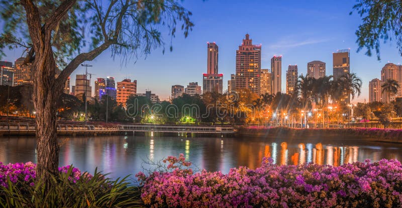 Lake in City Park under Skyscrapers at Night. Benjakiti Park in Bangkok, Thailand