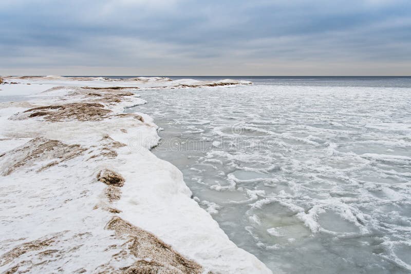 Winter Snow Covered Tree And Rocks By Frozen Lake Stock Image - Image ...