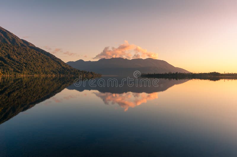 Lake landscape with mountain hills and reflection in still water