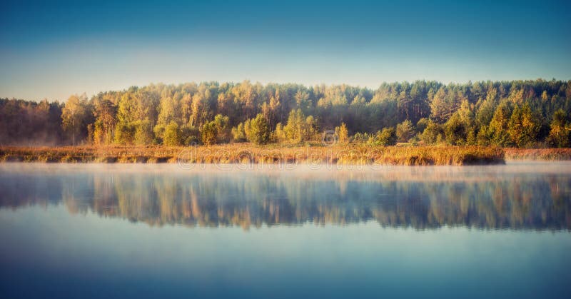 Lake at misty dawn stock photography
