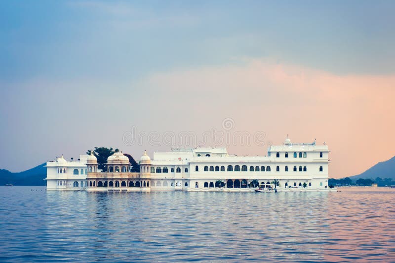 Romantic luxury India travel tourism - Lake Palace Jag Niwas complex on Lake Pichola on sunset with dramatic sky, Udaipur, Rajasthan, India. Romantic luxury India travel tourism - Lake Palace Jag Niwas complex on Lake Pichola on sunset with dramatic sky, Udaipur, Rajasthan, India