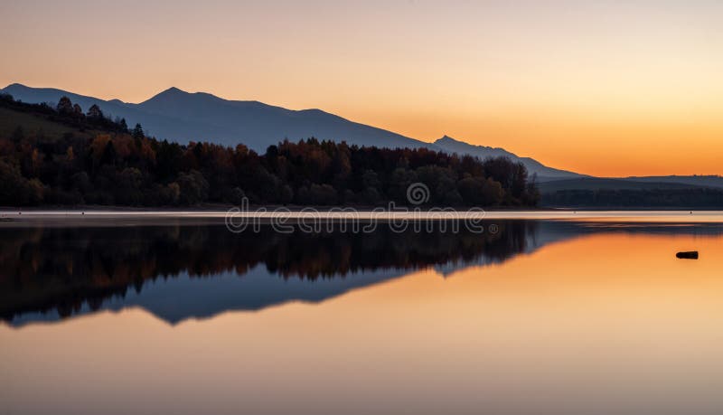 Lake sunrise landscape. Water reflection of mountain. Tatras mouuntains at background. Slovakia