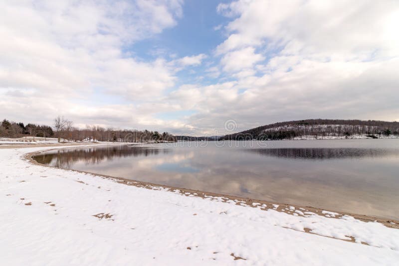 Lake Taghkanic State Park swimming beach in winter after first snowfall, upstate rural New York and cloud reflections, upstate rural New York