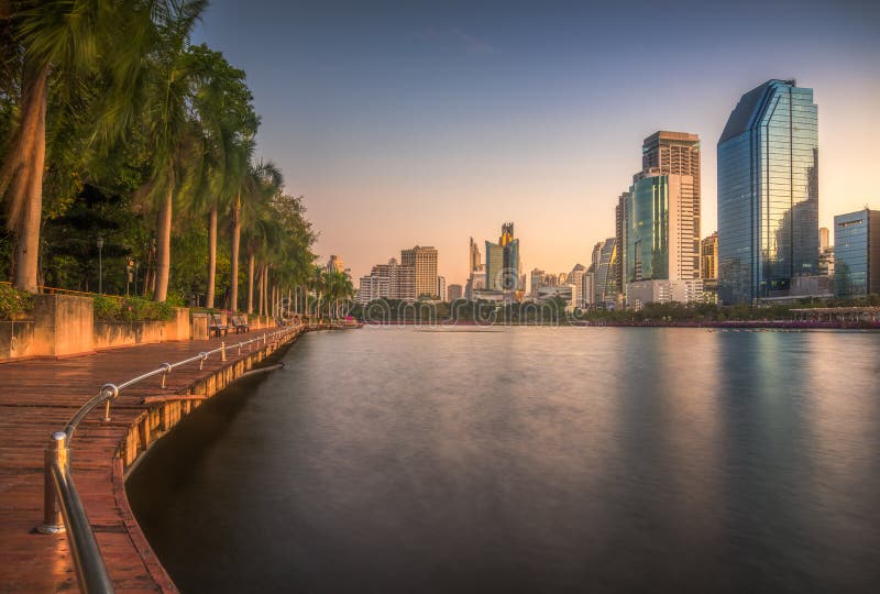 Lake with Wooden Walk Way in City Park. View of Benjakiti Park at Sunrise. Beautiful Morning Scene of Public Park in Bangkok, Thailand, Asia