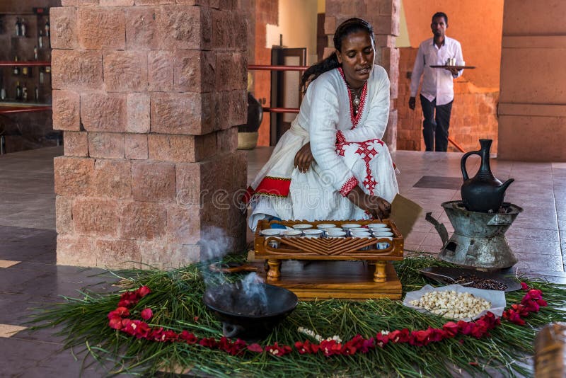 Lalibela, Ethiopia - Feb 14, 2020: Young woman in traditional clothing is preparing a coffee ceremony