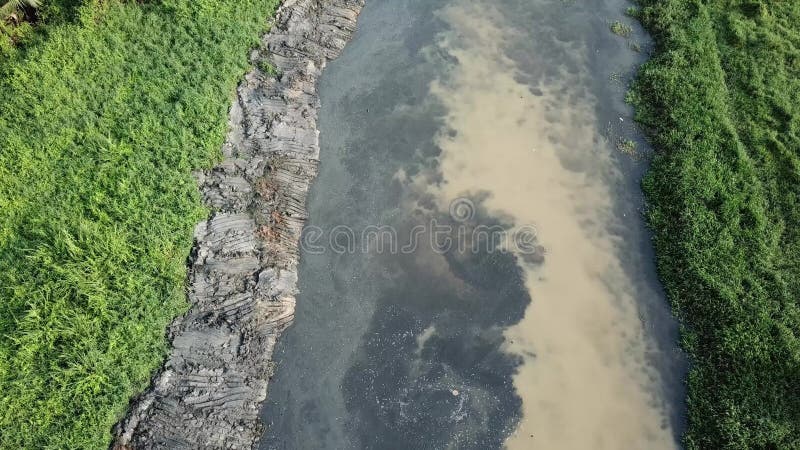 Lama suja vista aérea no rio após o alargamento